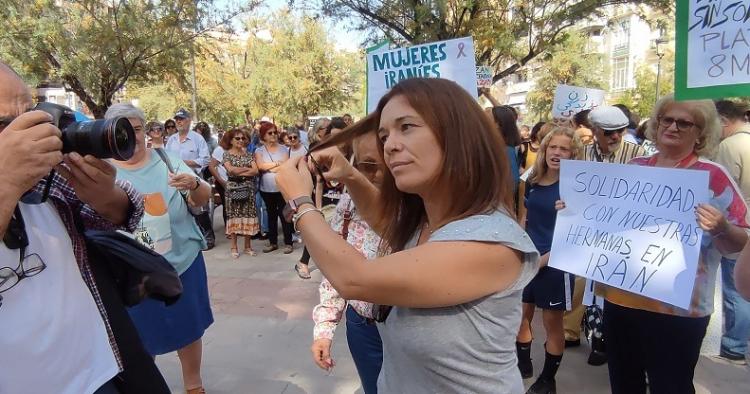 Una mujer se corta un mechón de pelo.