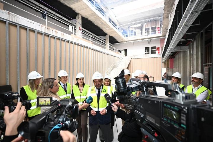 Responsables políticos atienden a los medios dentro del edificio en obras. 