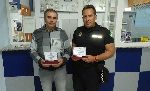 Los dos agentes, con las placas recibidas. 