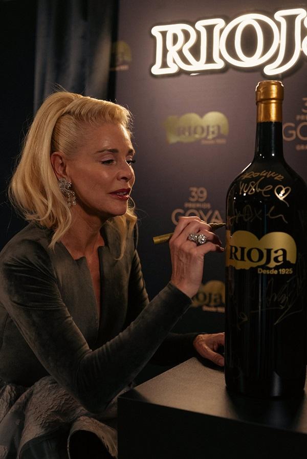 La actriz Belén Rueda firma una de las botellas especiales de Rioja del centenario que han desaparecido tras los Goya.