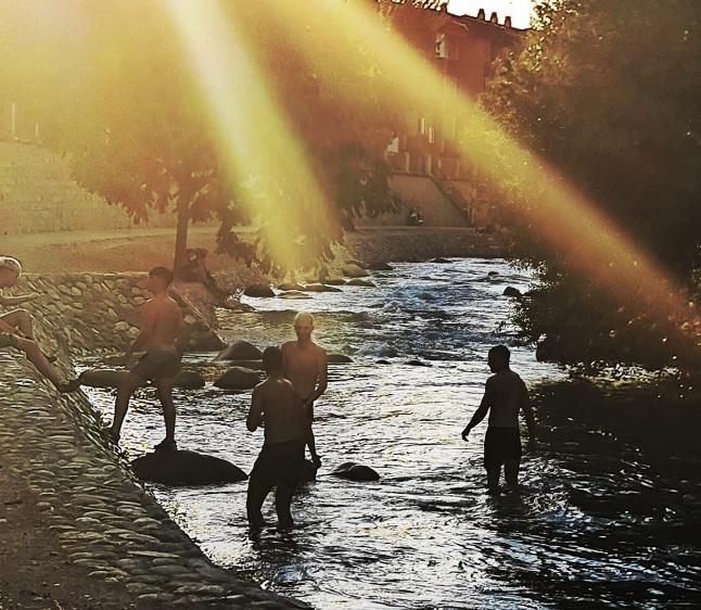 Jóvenes se refrescan al atardecer en el río Genil. 