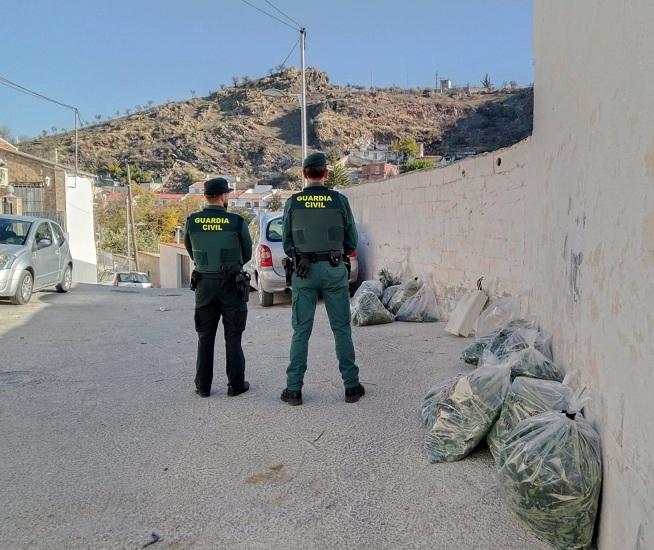 Agentes, junto a varias bolsas con marihuana requisadas. 