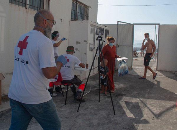 Voluntariado de Cruz Roja toma la temperatura y presta una primera asistencia a los migrantes.