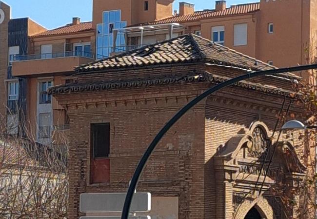 Imagen del arco de entrada a la antigua prisión con el agujero en el tejado.