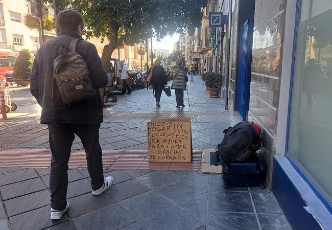 Cartel y pertenencias de un joven sin hogar en la Acera del Darro.