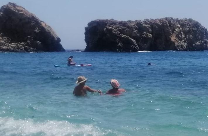 Dos personas se bañan con la cabeza cubierta en la playa de la Rijana.