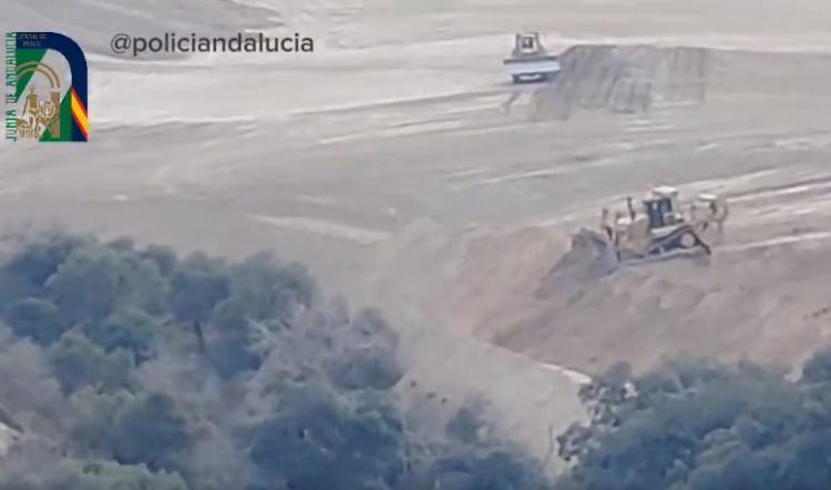 Maquinaria pesada sepulta de tierra la vegetación de un barranco durante las obras. 