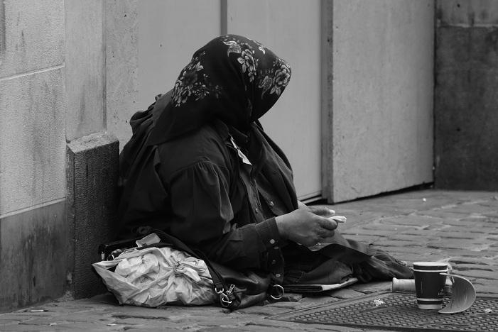 Una mujer pide en la calle. 