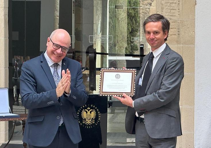 El rector Pedro Mercado entrega una placa al responsable de Lactalis Puleva, David Saliot.