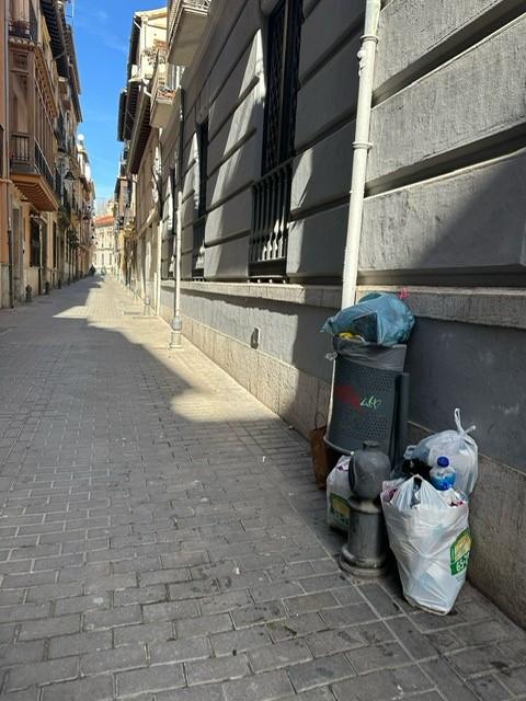 Basura en una papelera en el Barrio de la Virgen.