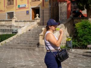 Una chica se refresca con un helado en el entorno de Plaza Nueva.