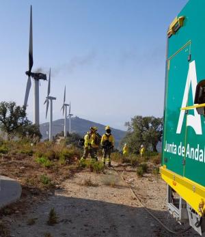 Dispositivo del Infoca en torno al aerogenerador, quemado y humeante. 