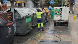 Limpieza de contenedores en una calle de la capital. 