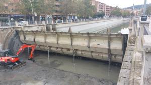 Maquinaria recogiendo lodos depositados junto a la compuerta. 