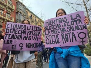 Dos mujeres jóvenes con sendas pancartas contra la ola reaccionaria, en la manifestación del 8M en Granada.