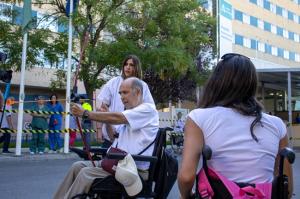 Un paciente prueba el arco con flecha asesorado por una profesional.