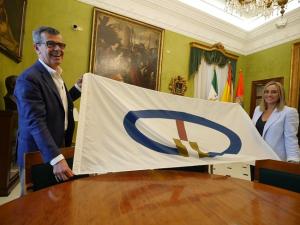 Marifrán Carazo y Juan Ramón Ferreira, con la bandera que se izará en el Ayuntamiento el 8 de septiembre.