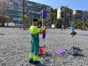 Un operario coloca una pegatina en una sombrilla.