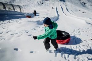 Un niño se dispone a lanzarse con un flotador en la zona de Borreguiles de la Estación de Sierra Nevada.