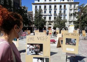 Una mujer observa las fotografías exhibidas en la Plaza del Carmen. 