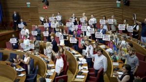 Diputados de izquierda con carteles en los que se puede leer "Veritat, Justícia, Reparació".